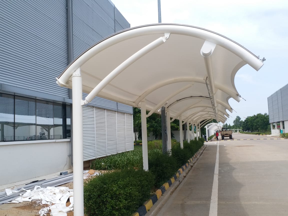 White tensile membrane walkway roofing installed for an industrial building by Arasuvel Roofings